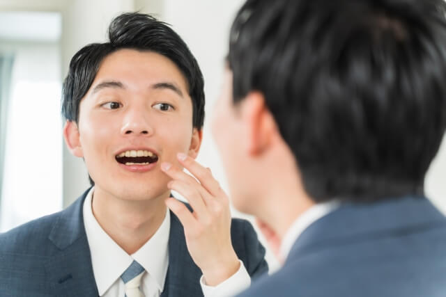 鏡の前で笑顔をみせる男性