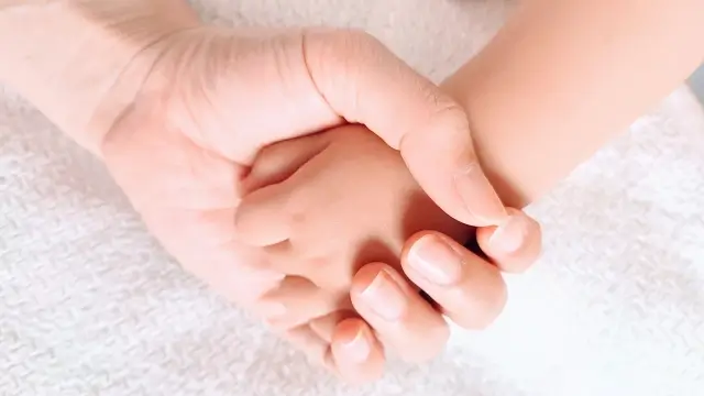 子供の手をにぎる親の手
