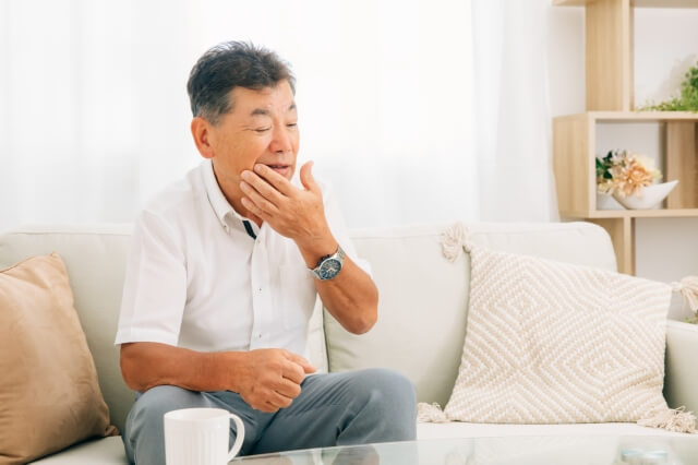 口元を触る男性
