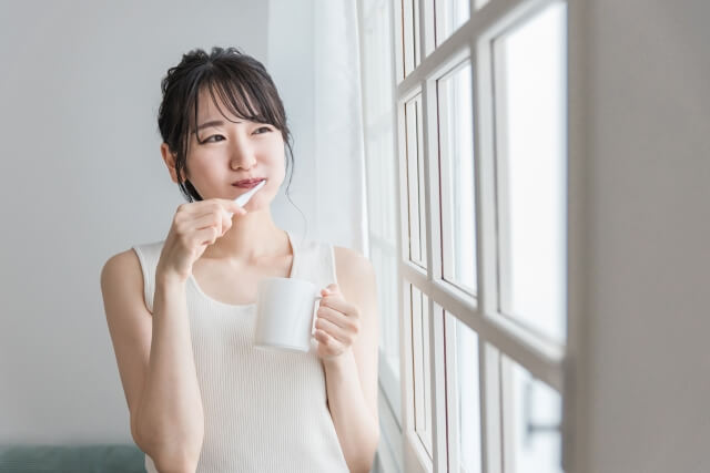 歯磨きをする白い服の女性