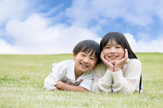 芝生の上で笑う男の子と女の子