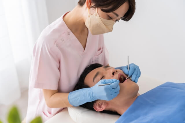 患者の口腔内をクリーニングする歯科衛生士